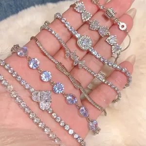 Bracelets argentés de style coréen avec breloques en zircon coeur et papillon sur la main.