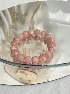 Primo piano di bracciale in quarzo rosa craquelé con distanziatori floreali dorati
