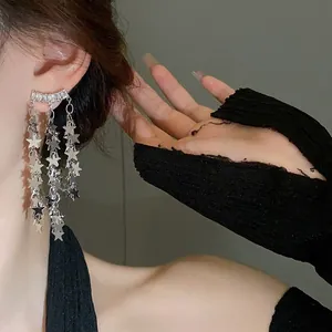 Détail de boucles d'oreilles pampilles en argent avec paillettes étoiles et strass brillants