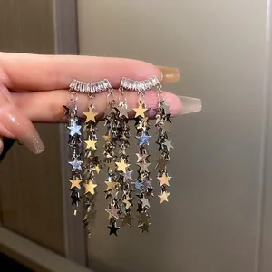 Détail de boucles d'oreilles à pampilles étoiles argentées et cristaux