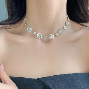 Primo piano di una collana girocollo con pendenti circolari in cristallo lucido