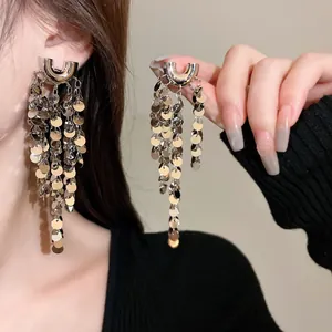 Gros plan de boucles d'oreilles à pompons et paillettes argentées