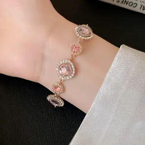 Elegante bracciale in oro rosa con cristalli rosa e aloni di strass pavé su un polso