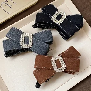 Elegant rhinestone fabric bow hair clips in black, grey and brown shown in a tray.