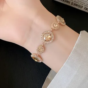 Elegante bracciale in oro rosa con cristalli champagne e pavé di strass sul polso