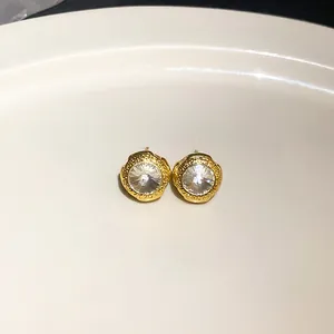 Detailansicht von goldfarbenen Ohrsteckern mit einem großen facettierten Zirkonia.