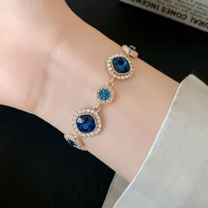 Vista ravvicinata di un elegante bracciale dorato con cristalli blu e strass scintillanti