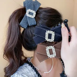 Close-up detail of elegant rhinestone bow banana hair clips in grey, black, and brown