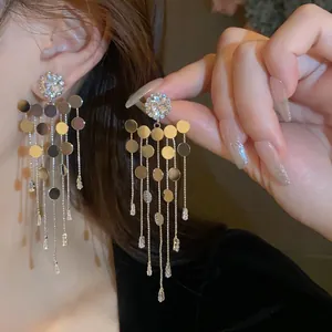 Gros plan de boucles d'oreilles à pompons avec strass étincelants et aiguilles en argent pur