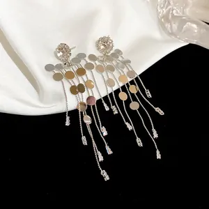 Vue détaillée de boucles d'oreilles à pampilles en argent avec paillettes et cristaux.