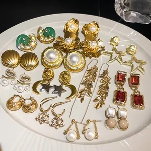 Detaillierte Makroansicht verschiedener goldfarbener Vintage-Ohrringe mit Perlen