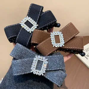 Detailed macro shot of fabric bow hair clips featuring elegant rhinestone square buckles.