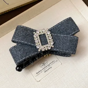 Detail showing the rhinestone buckle and fabric texture of this elegant bow hair clip