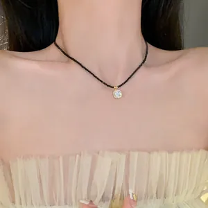 Vue détaillée d'un collier minimaliste en perles noires avec pendentif en cristal