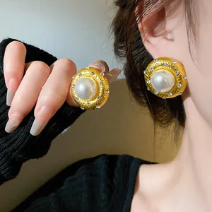 Detail von Vintage-Ohrringen in Goldoptik mit großer Perle und Zirkon-Halo