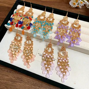 Dettaglio ravvicinato di orecchini pendenti bohémien in perline di vetro multicolore.