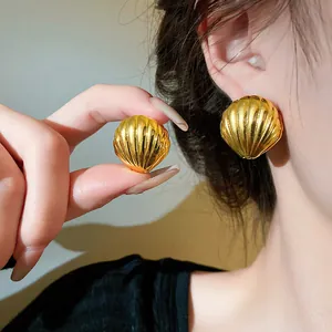 Detailansicht eleganter goldener Muschelohrstecker mit glänzendem Metallfinish-Effekt