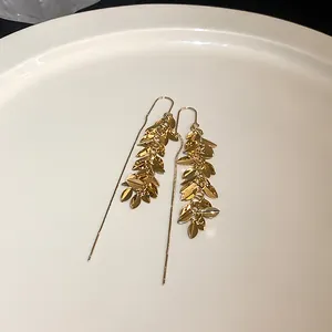 Detailaufnahme eleganter goldfarbener Ohrringe mit kaskadierendem Blatt-Design