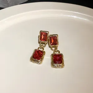 Elegante Detailansicht von Vintage-Goldohrringen mit roten rechteckigen Zirkonia.