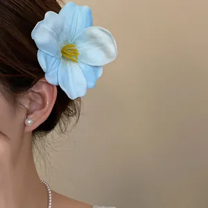 Dettaglio di un fermaglio per capelli a forma di fiore blu in schiuma su modella