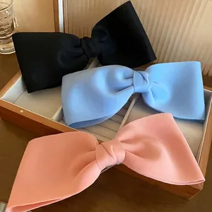 Elegant set of three oversized fabric bow hair clips in black, soft blue and peach pink colors