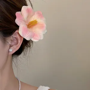 Primo piano di un fermaglio per capelli a fiore in schiuma rosa per le vacanze.