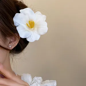 Dettaglio dell'elegante fermaglio per capelli a fiore in schiuma bianca per stile resort