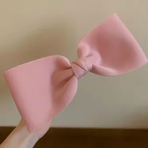 Close-up of large pink fabric bow hair clip featuring an elegant Korean minimalist design