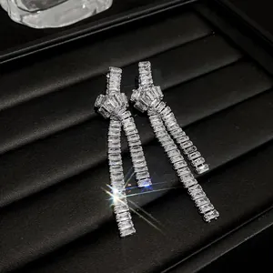 Detailed macro view of elegant silver knot earrings with long sparkling zirconia tassels
