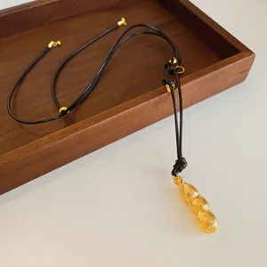 Collier élégant avec pendentif cacahuète doré et cordon noir réglable