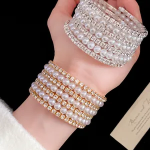 Detail of elegant multi-layer bracelets featuring pearls and sparkling rhinestones.