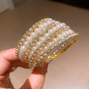 Close-up detail of luxury multi-layer gold bracelet with pearls and sparkly rhinestones