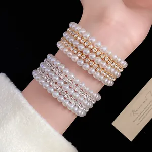 Close-up of vintage multi-layer bracelets with white pearls and sparkling rhinestones.