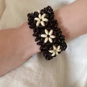 Handmade bohemian multi-layer wooden beaded bracelet with flower pattern on woman's wrist