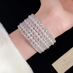 Detail of multi-layer bracelet featuring white pearls and rows of sparkling rhinestones