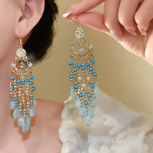 Primo piano di orecchini bohémien retrò in stile etnico con perle di vetro blu