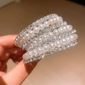 Close-up detail of multi-layer bracelet with elegant pearls and sparkling rhinestones.