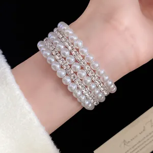 Close-up detail of elegant multi-layer pearl and rhinestone bracelet worn on a wrist