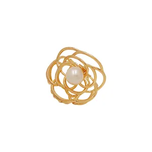Elegante fermaglio per capelli a fiore in metallo dorato con perla su sfondo bianco