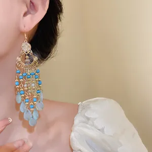 Dettaglio ravvicinato di orecchini vintage boho con perline blu e finitura dorata.