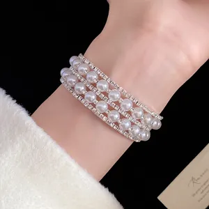 Close-up of multi-layer pearl and rhinestone open bangle in French retro style
