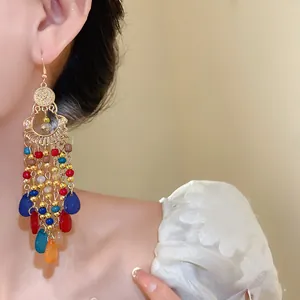 Dettaglio macro di orecchini bohémien con perline di vetro colorate su modella