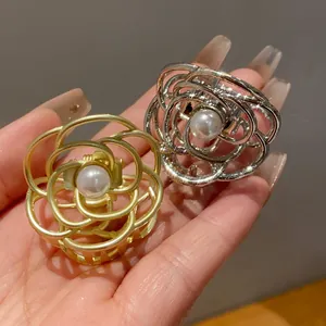 Vista dettagliata di eleganti mollette per capelli a fiore con perle in oro e argento