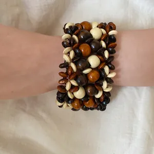 Detailed view of bohemian multilayer wooden bead bracelet in earthy tones on wrist