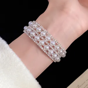 Elegant close-up detail of multi-layer pearl and rhinestone bracelet on the wrist