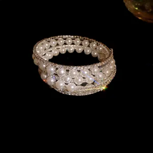 Detailed view of an elegant vintage multi-layer pearl and rhinestone wrap cuff bracelet