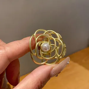 Dettaglio di un fermaglio per capelli vintage a forma di fiore in metallo dorato.