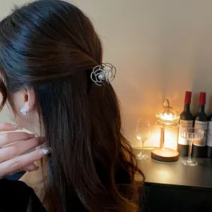 Dettaglio di un'elegante molletta per capelli a fiore in metallo con perla tra i capelli