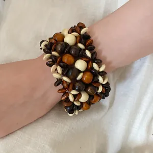 Close-up detail of bohemian multi-layer wooden bead bracelet worn on a female wrist