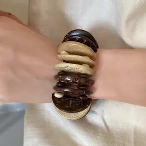 Close-up of bohemian multilayer bracelet featuring natural wood and coconut shell disks